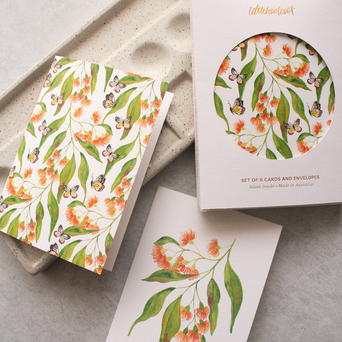 Set of floral cards and envelopes with a matching box on a grey surface