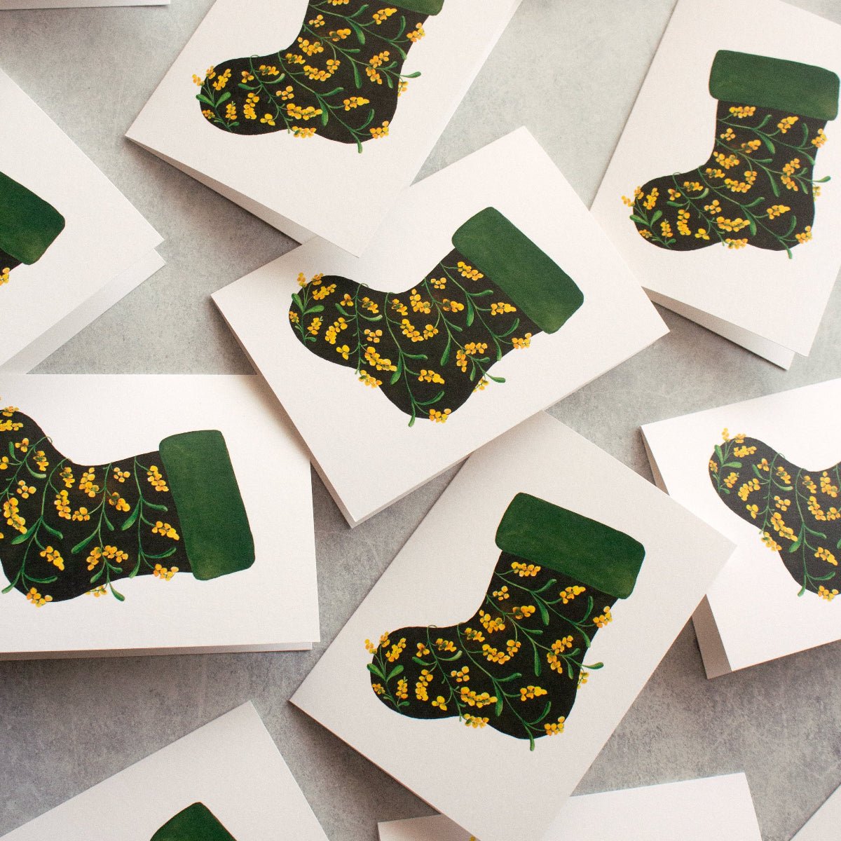 Greeting cards with green and yellow patterned stockings on a grey surface