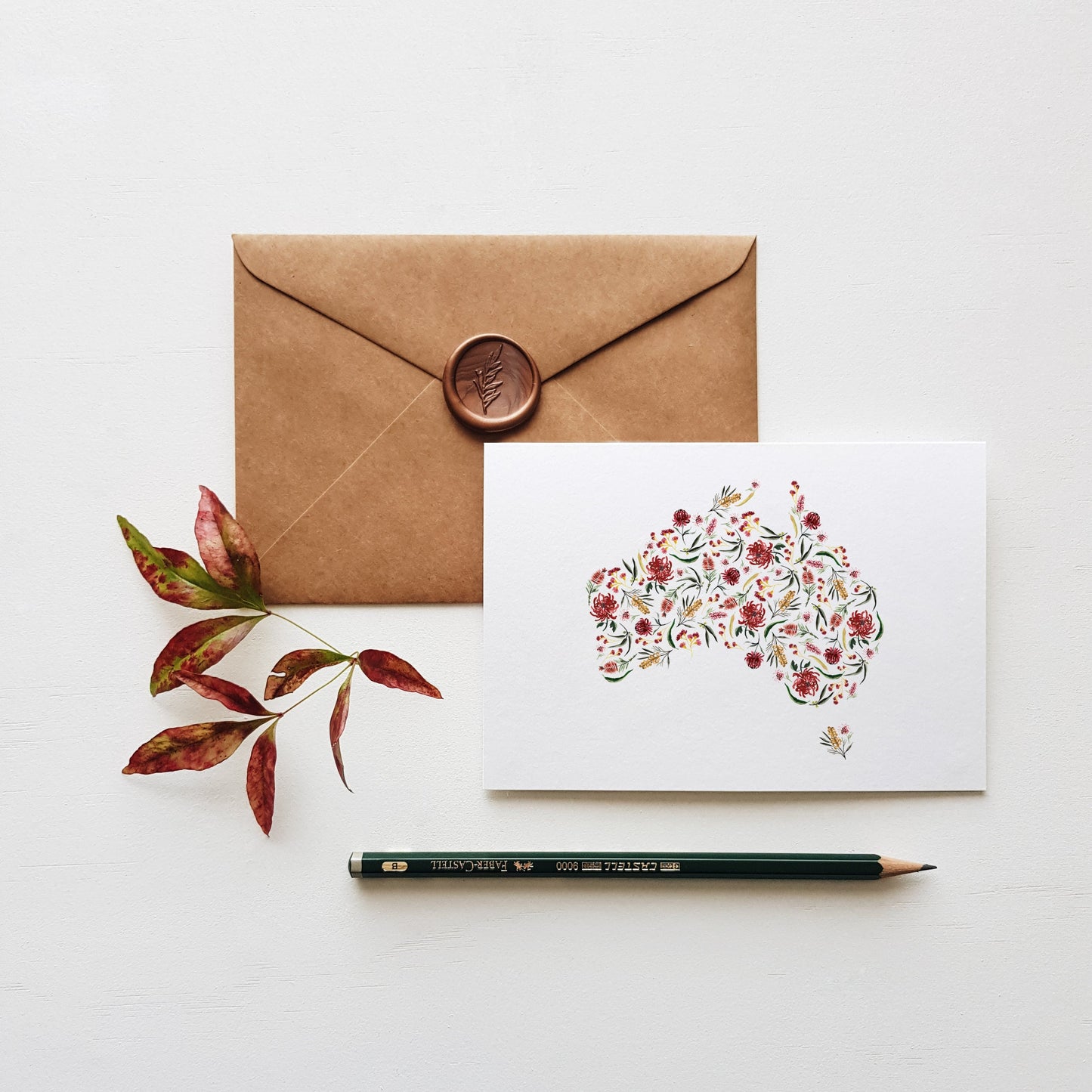Greeting card of australia with brown envelope, leaves and pencil