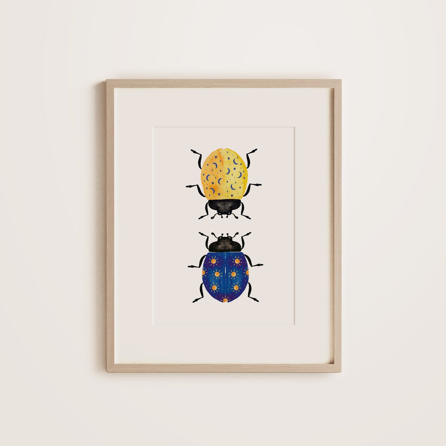 A wooden framed print featuring two ladybugs in different colors on a white background