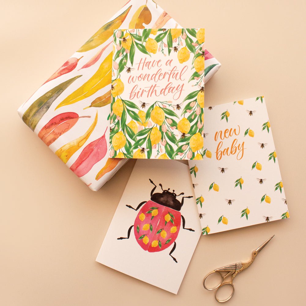 Set of greeting cards with fruit and nature-themed designs on a beige background.