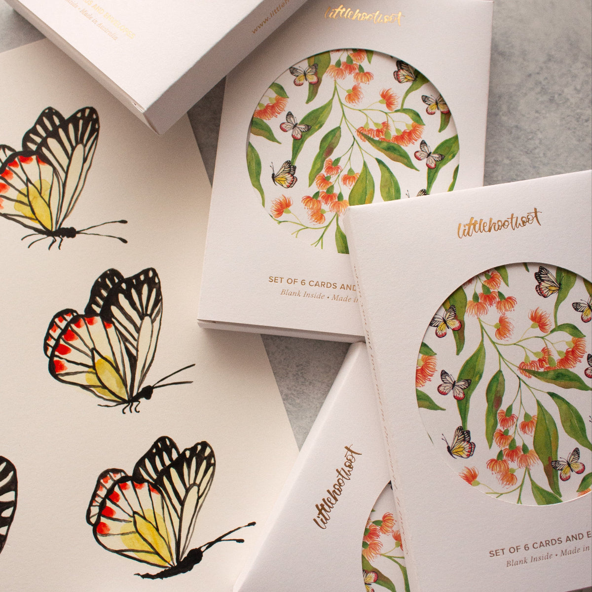 Set of cards with butterfly designs on a grey surface