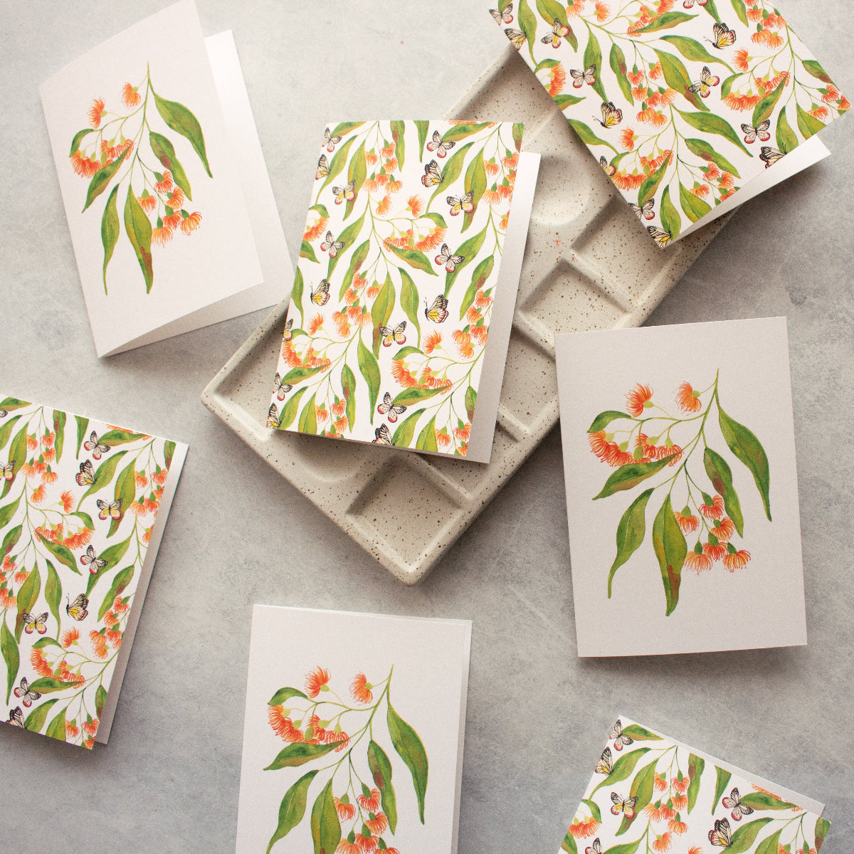 Set of greeting cards with floral designs on a gray surface
