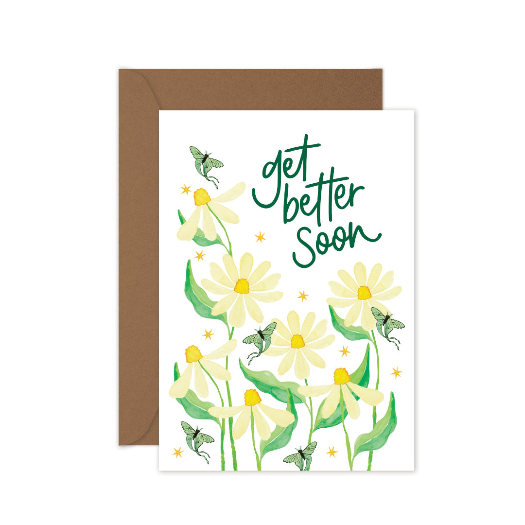 Get well soon greeting card featuring cream daisies, teal luna moths, and a kraft envelope. The card displays 'Get Better Soon' in deep green hand lettering, offering a heartfelt message of comfort and encouragement.