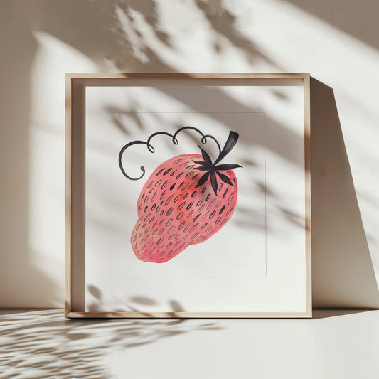 Framed artwork of a pink strawberry with black seeds on a light background