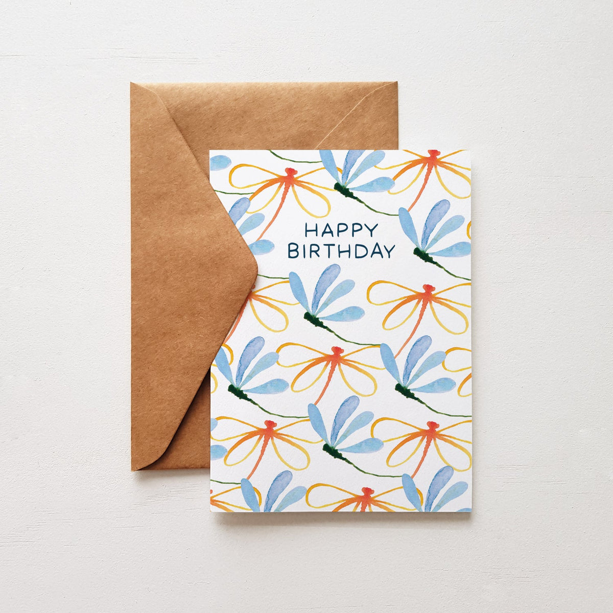 Happy birthday card with blue and orange dragonflies and a brown envelope