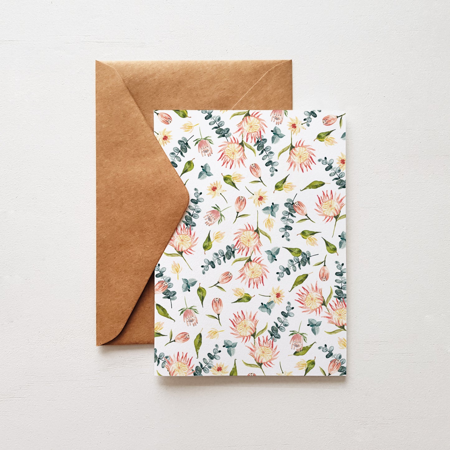 Greeting card featuring a hand-painted watercolour protea illustration, paired with a kraft envelope.