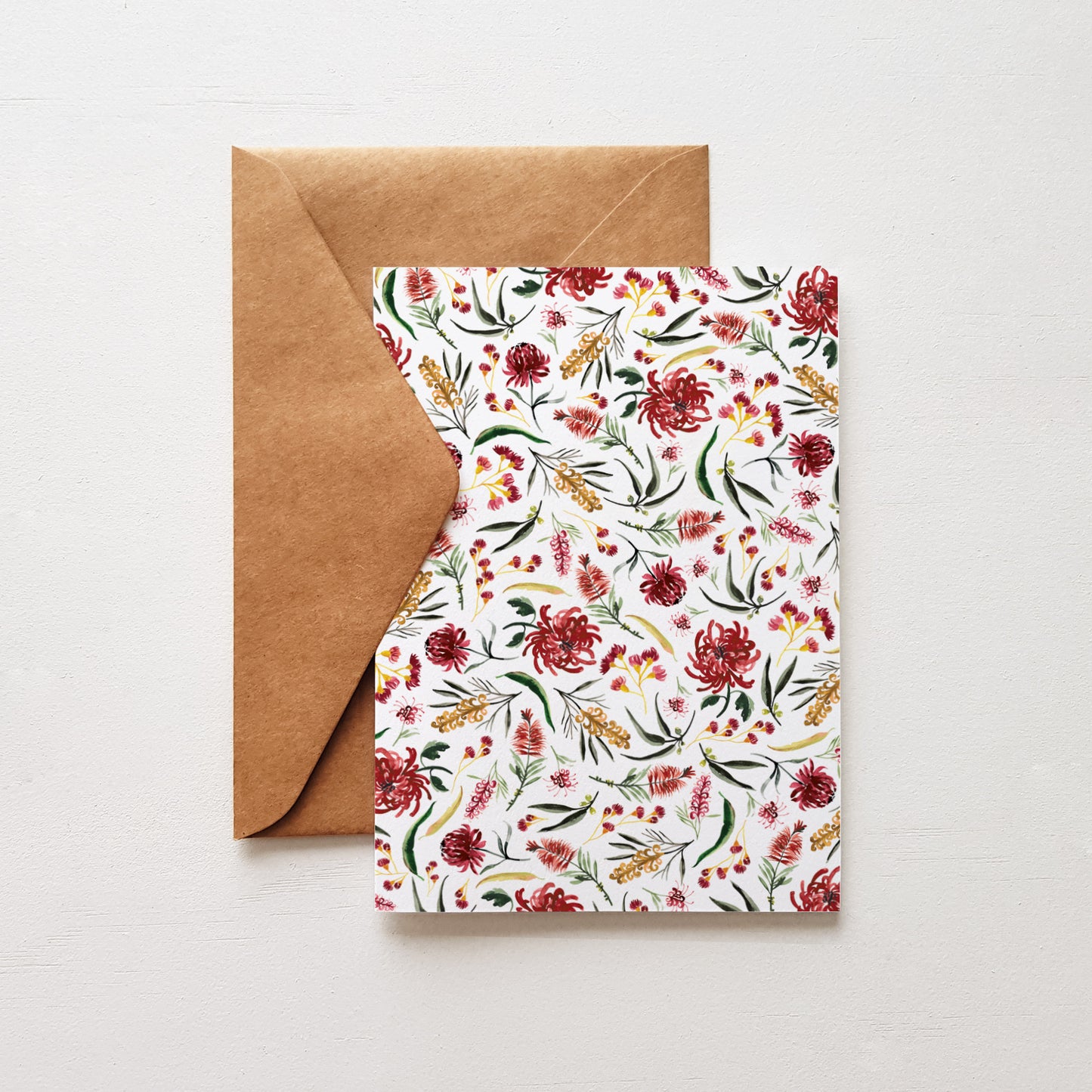 Greeting card featuring a red waratah flower pattern on the front, paired with a natural kraft envelope.