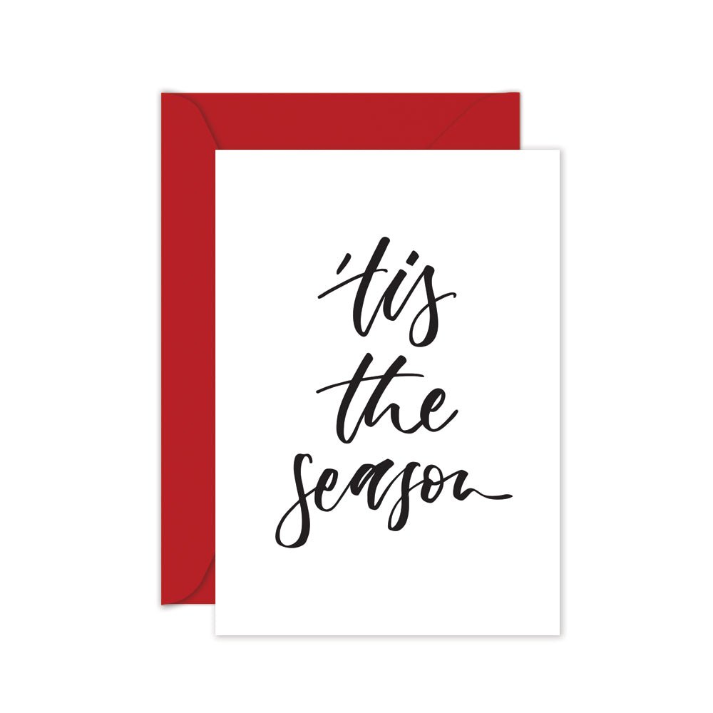 Christmas card with black script 'tis the season' on a red envelope