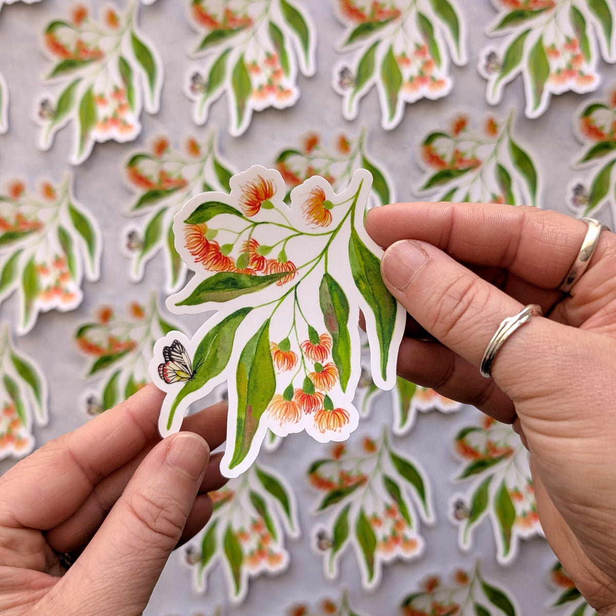 Hand holding a floral sticker with a matching background