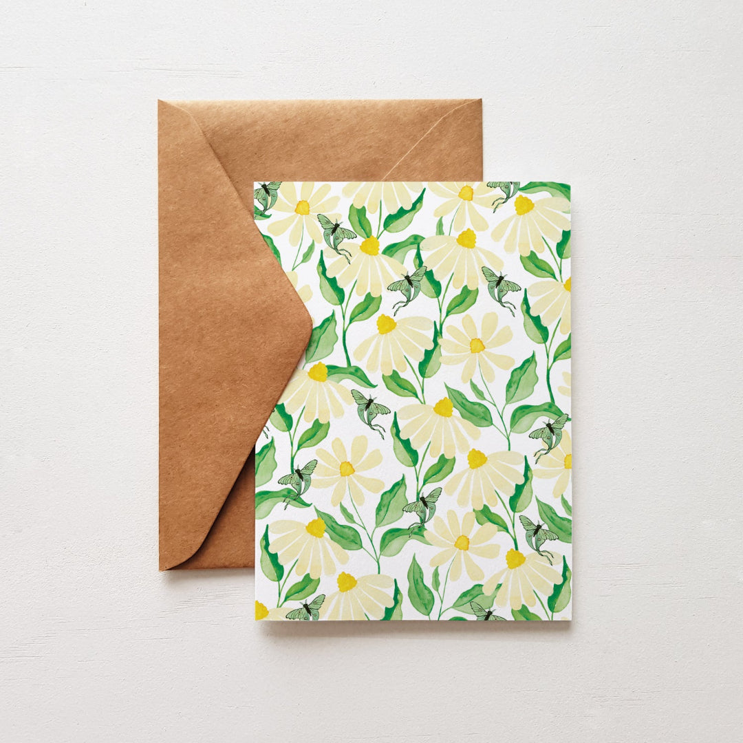 Whimsical daisy and luna moth greeting card displayed with a kraft envelope, ideal for thoughtful messages and special notes.