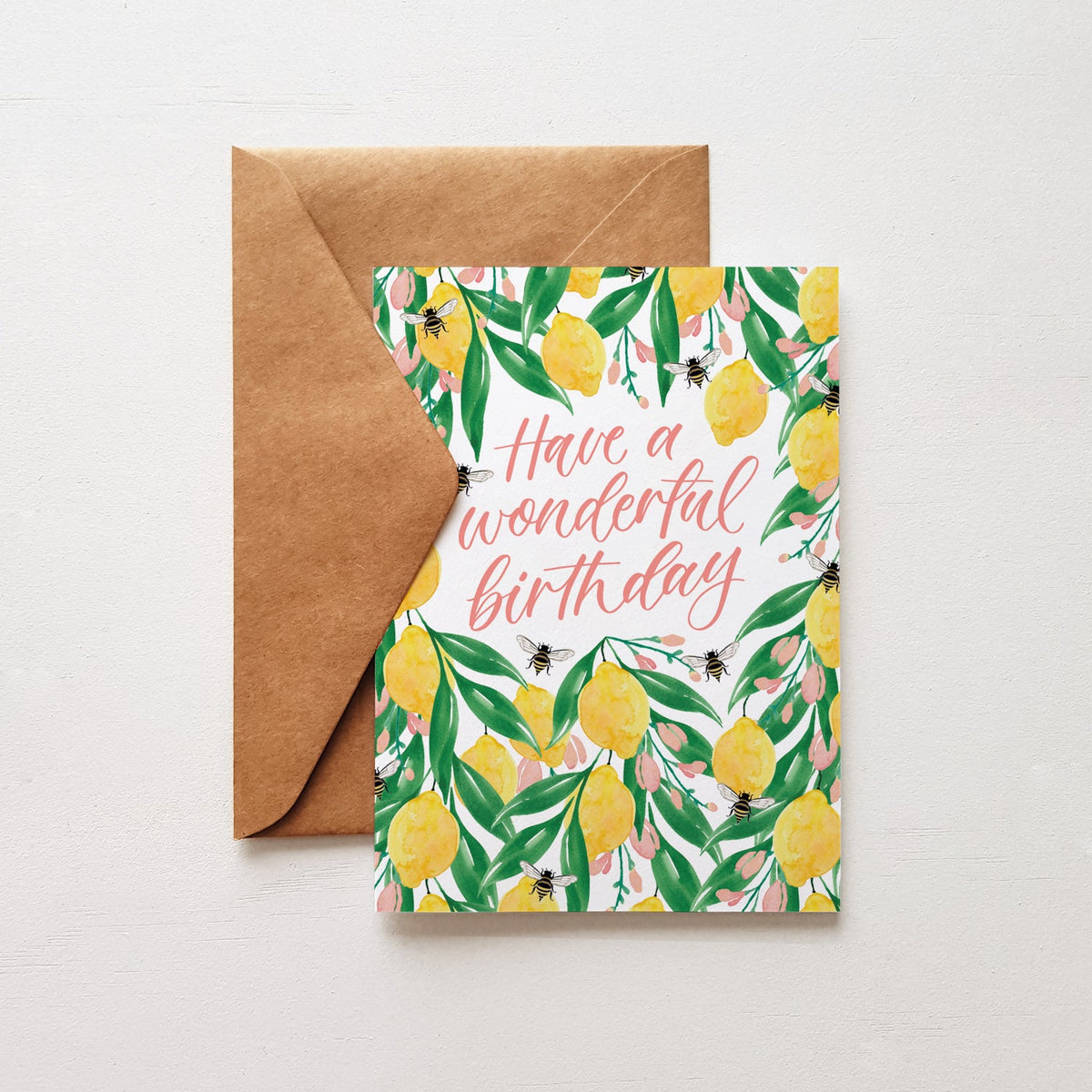 Greeting card with lemon design and 'Have a wonderful birthday' text, on a brown envelope on a light grey background.