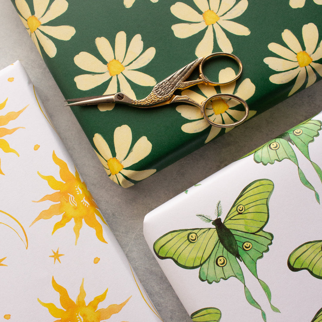 Wrapped presents featuring daisy patterns on deep green, sun and moon designs, and luna moths repeat patterns. A beautiful, nature-inspired gift wrap set.