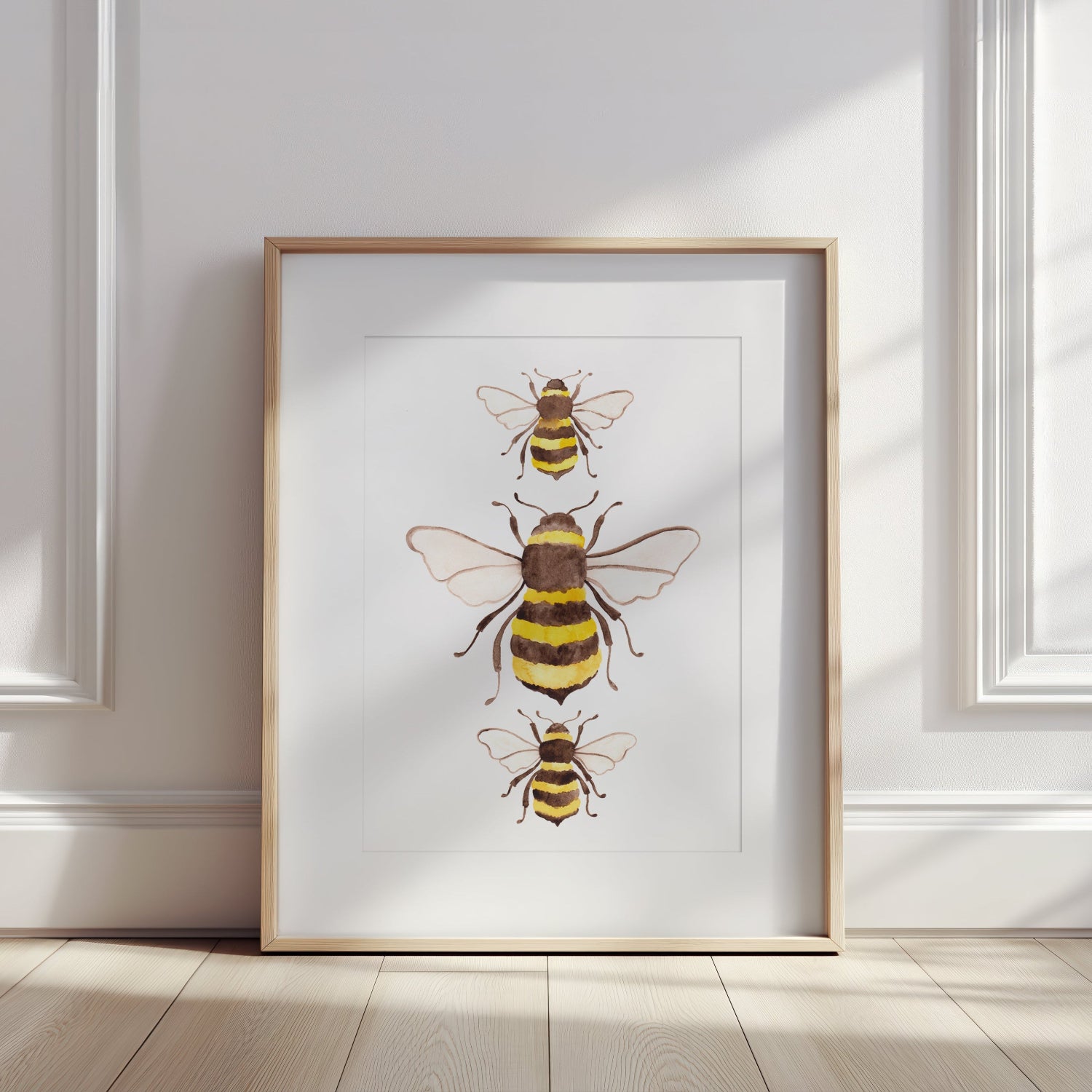 Framed artwork of bees on a white wall