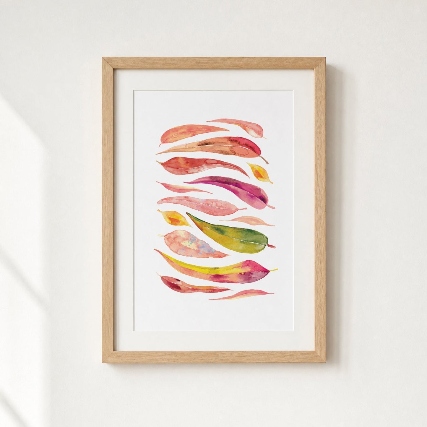 Framed artwork with colorful abstract leaf design on a white wall
