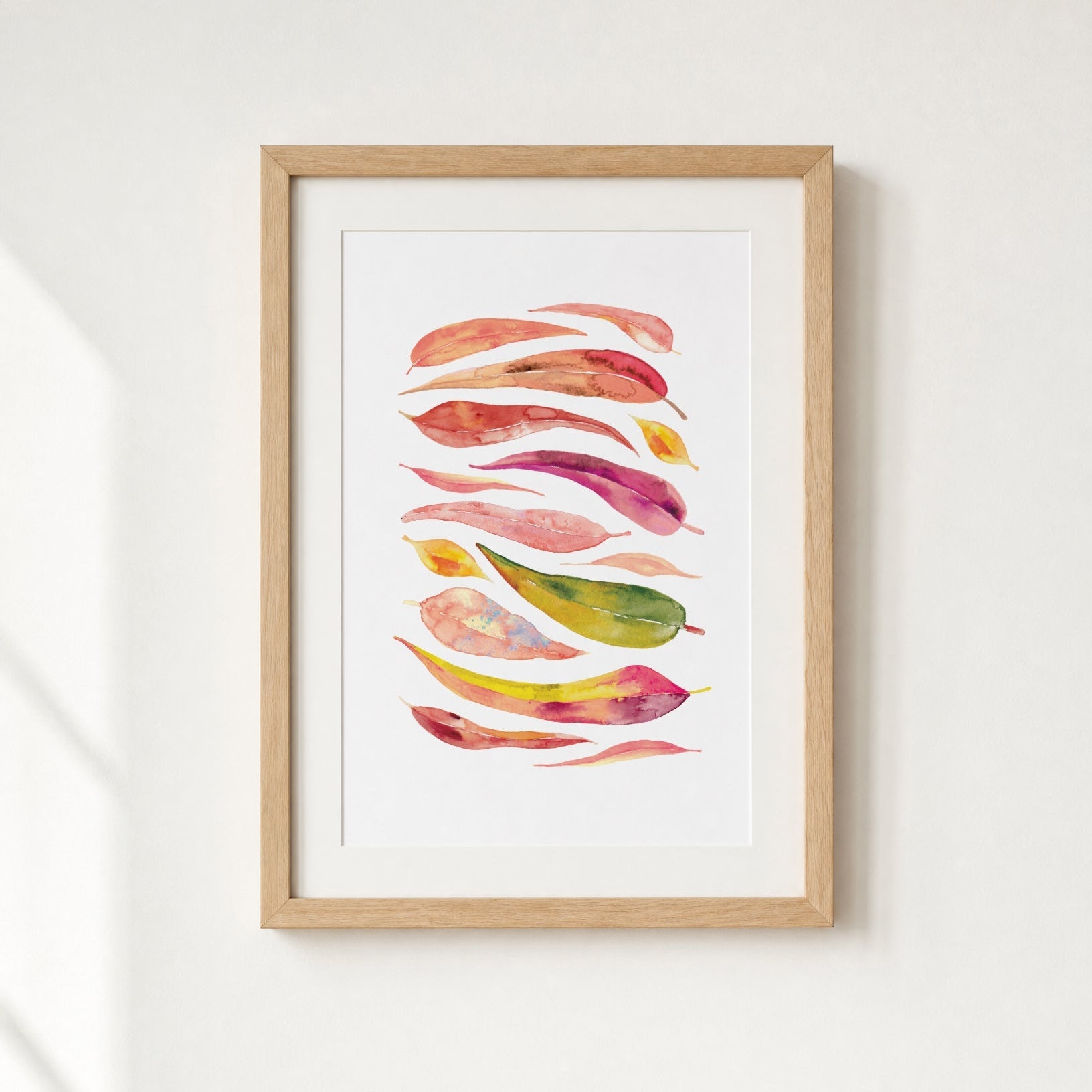 Framed artwork with colorful abstract leaf design on a white wall