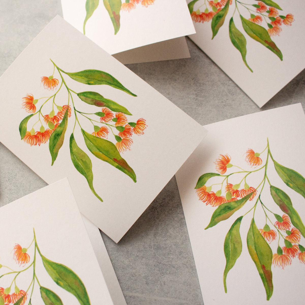 Greeting cards with floral designs on a grey surface