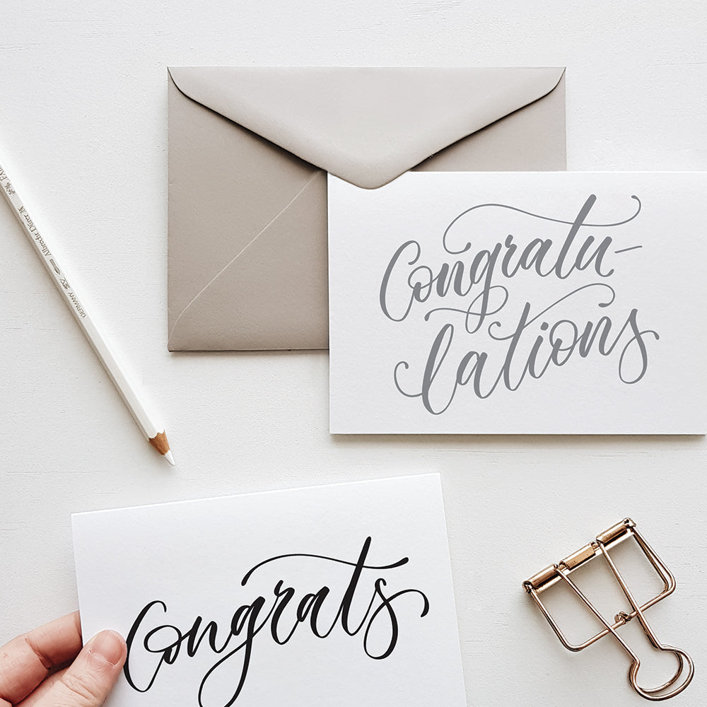 Grey envelope, greeting cards with congrats on them and stationery items