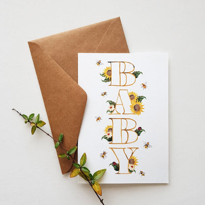 Sunflowers, bees and leaves sprouting out of the word BABY on a greeting card with a brown envelope