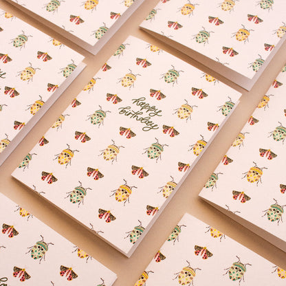 Botanical birthday card featuring beetle and moth illustrations in colourful tones