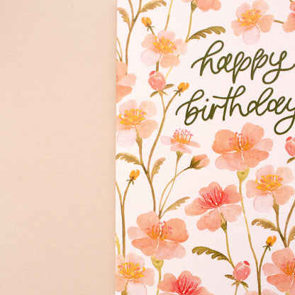 Floral birthday card with pink flowers and 'Happy Birthday' text on a beige background