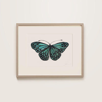 Framed artwork of a turquoise butterfly on a white background