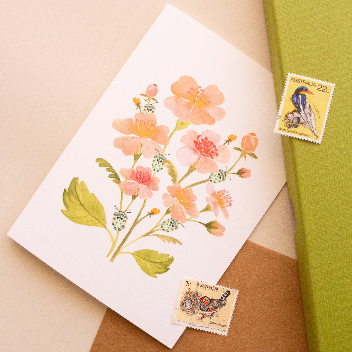 Botanical greeting card with soft pink flowers and teal beetle motif