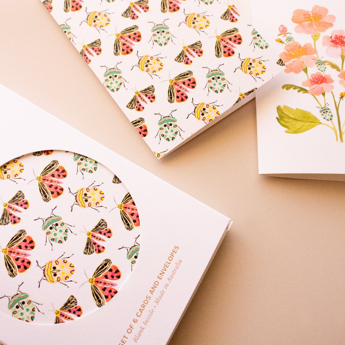 Botanical greeting card set with teal beetles, colourful moths and pink flowers