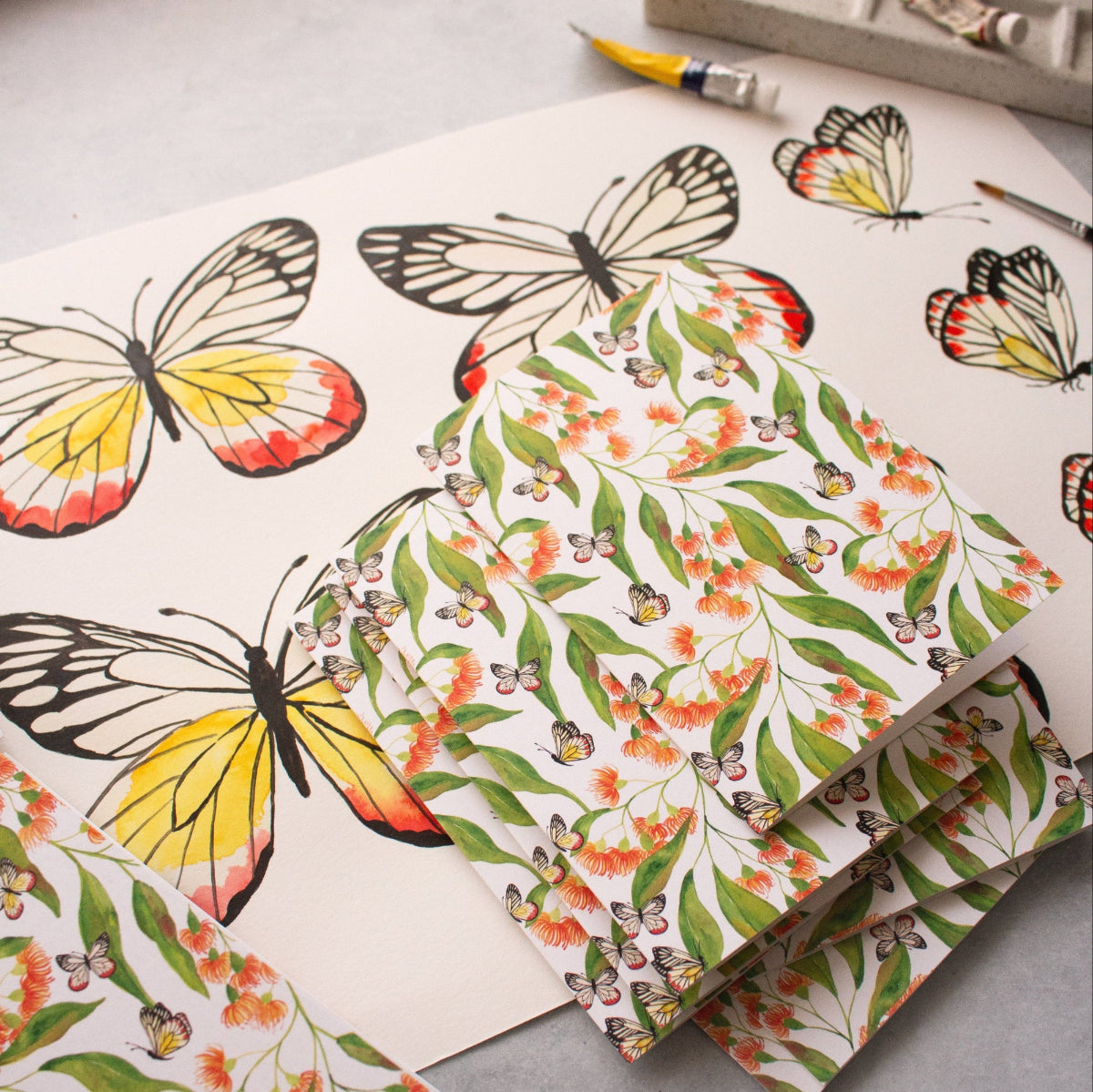 Florals and butterflies greeting cards on top of an original watercolour butterfly painting