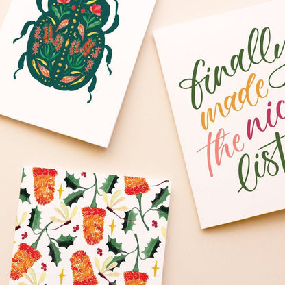 Three Christmas-themed greeting cards on a beige background