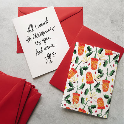 Greeting cards on red envelopes. One greeting card with banksia flowers and the other with black lettering and a wine glass