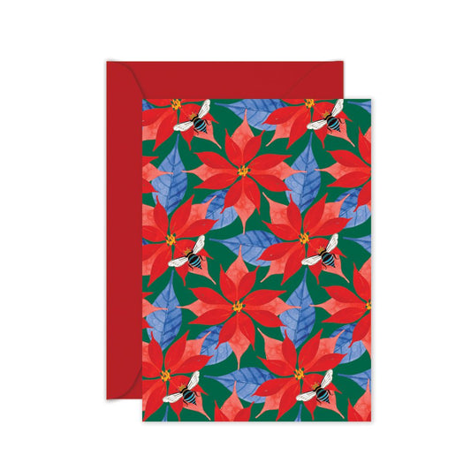 A Christmas card with a repeated pattern of red poinsettias and blue leaves on a green background, featuring a native blue banded bee. 