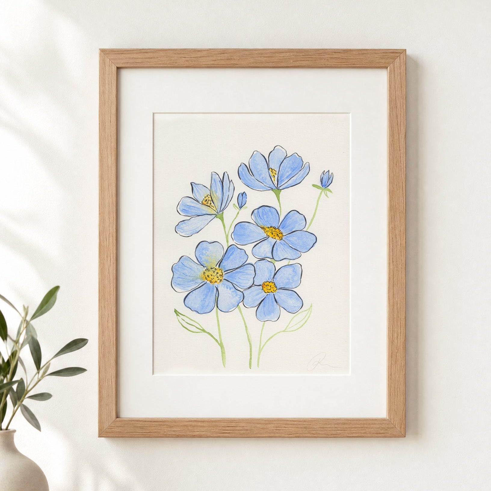 Wooden framed botanical painting of blue flowers with yellow centers, on a white wall, with a small vase and plant.