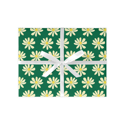 A sheet of wrapping paper with a green background and white daisy patterns, tied with a white ribbon.