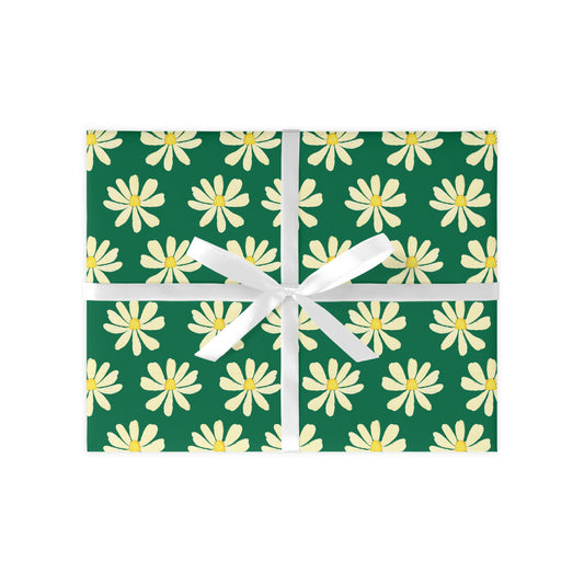 A sheet of wrapping paper with a green background and white daisy patterns, tied with a white ribbon.