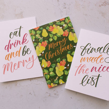 Three Christmas-themed cards on a textured surface