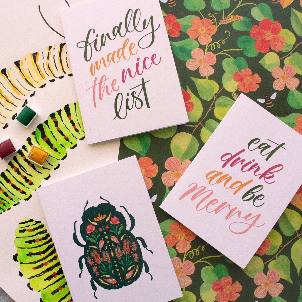Greeting cards with caterpillar illustrations and text on a floral background