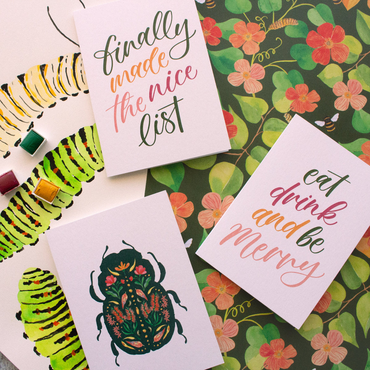 Greeting cards with caterpillar illustrations and text on a floral background