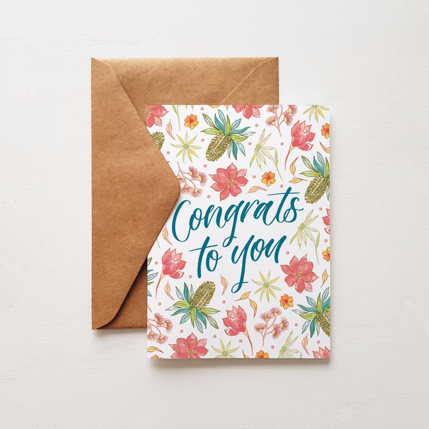 Floral congratulatory card with 'Congrats to you' text and brown envelope on a light gray background
