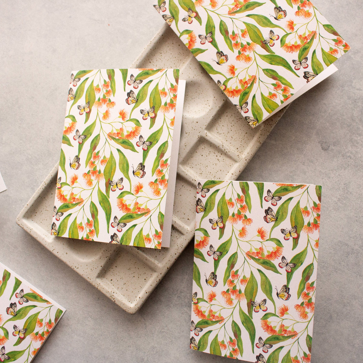 Floral-patterned greeting cards on a concrete surface