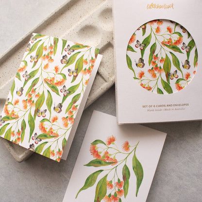 Set of floral cards and envelopes with a matching box on a grey surface