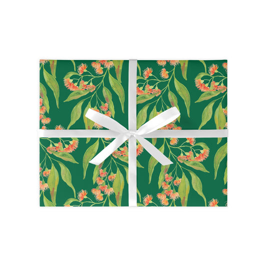 Gift box with floral design and white ribbon on a green background