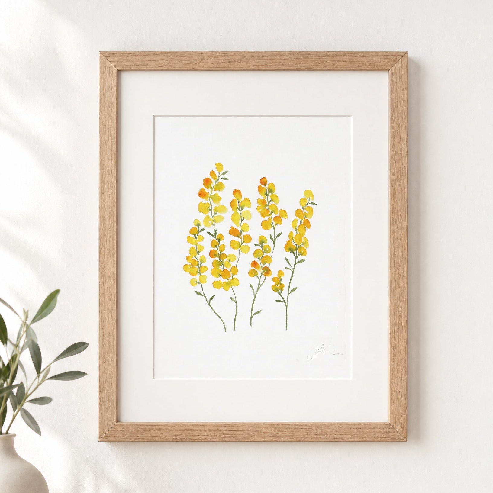 Framed artwork of yellow flowers on a white wall