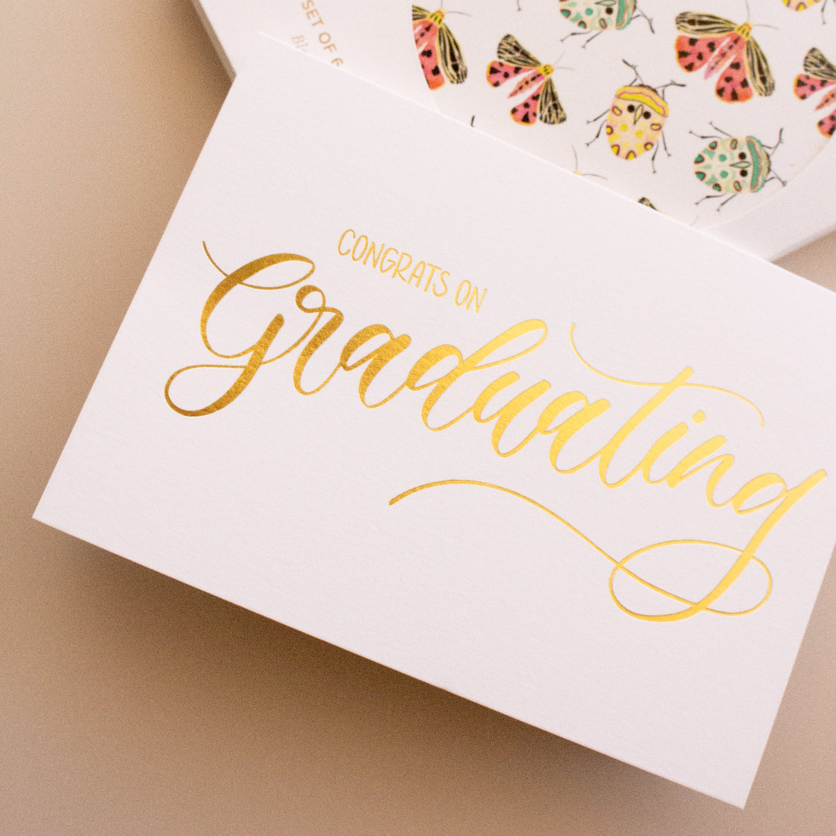 Graduation card with colourful illustrations and 'Congratulations on Graduating' text on a beige background