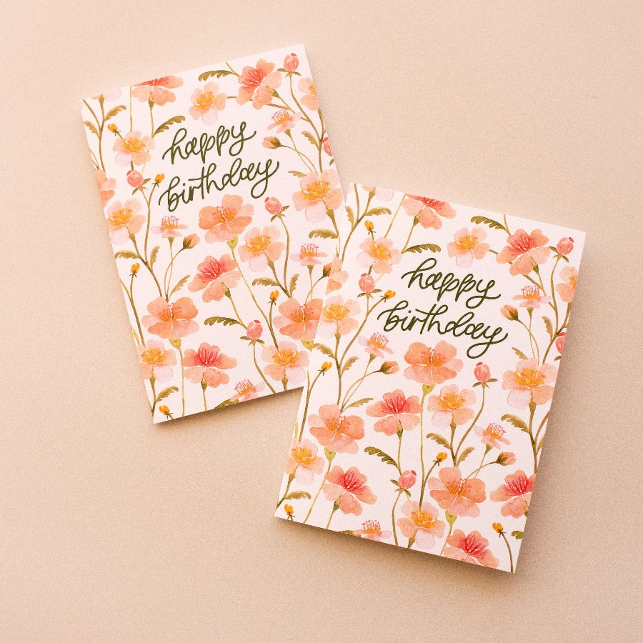 Two pink floral birthday cards on a beige background