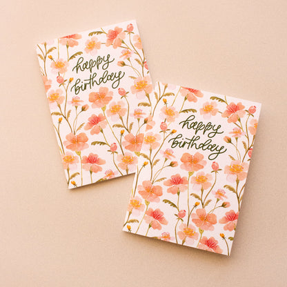 Two pink floral birthday cards on a beige background