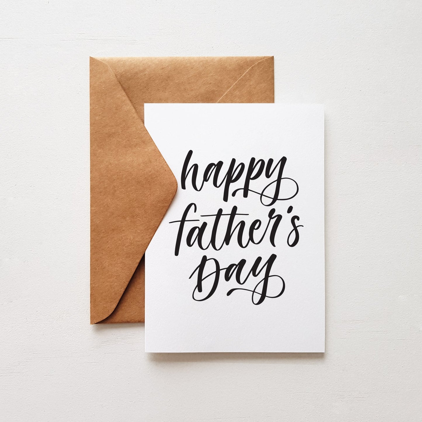black lettering happy fathers day greeting card with a brown kraft envelope