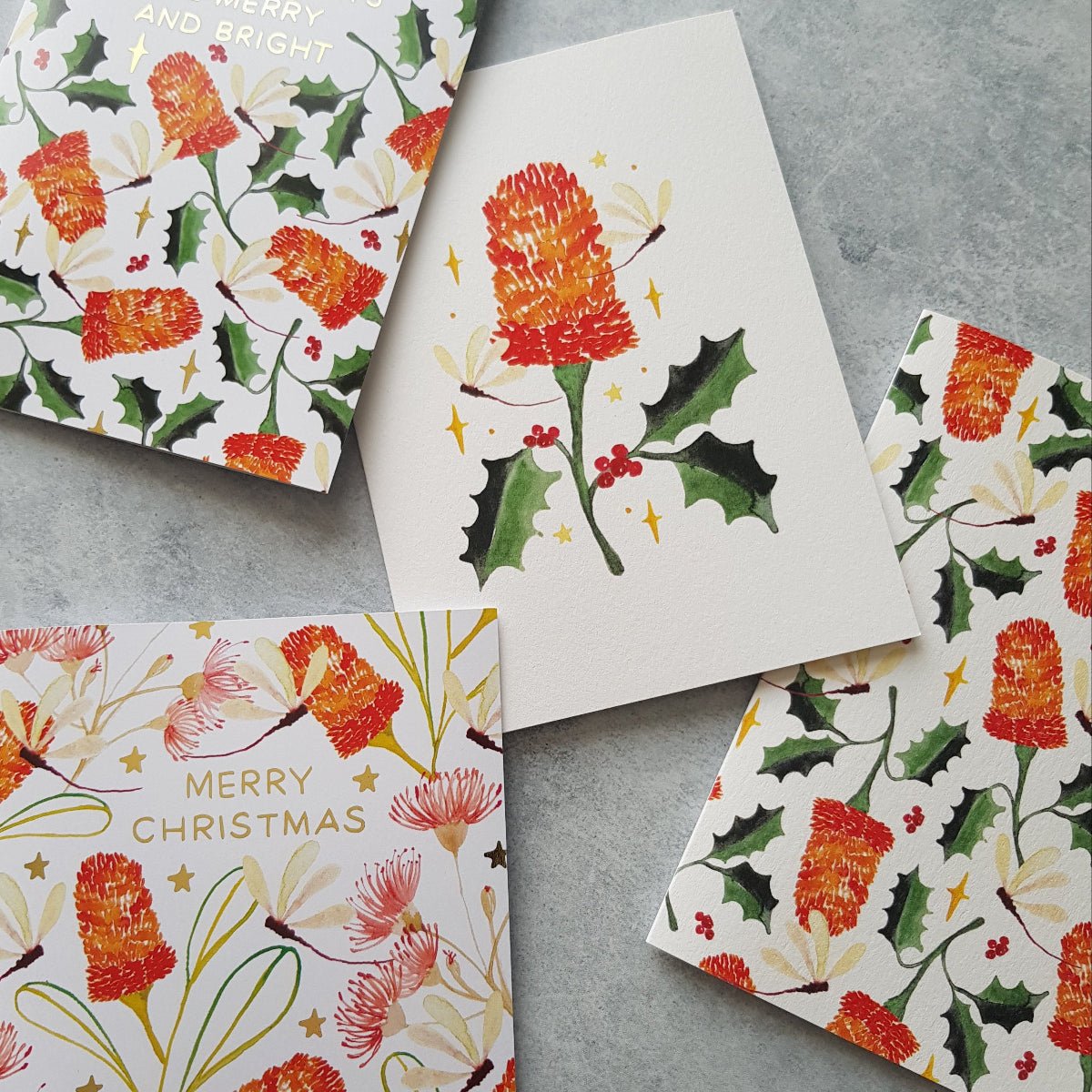 Four Christmas greeting cards with a botanical pattern of australian flowers in red and green