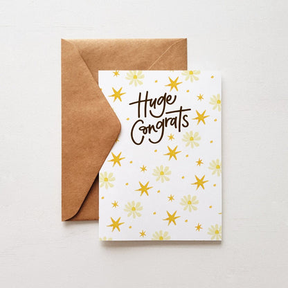 Huge Congrats greeting card featuring delicate daisies and yellow stars, paired with a kraft envelope.