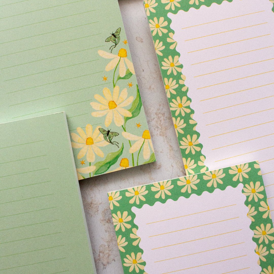 Teal DL notepada with a daisy design and lined pages, perfect for all your note-taking needs.